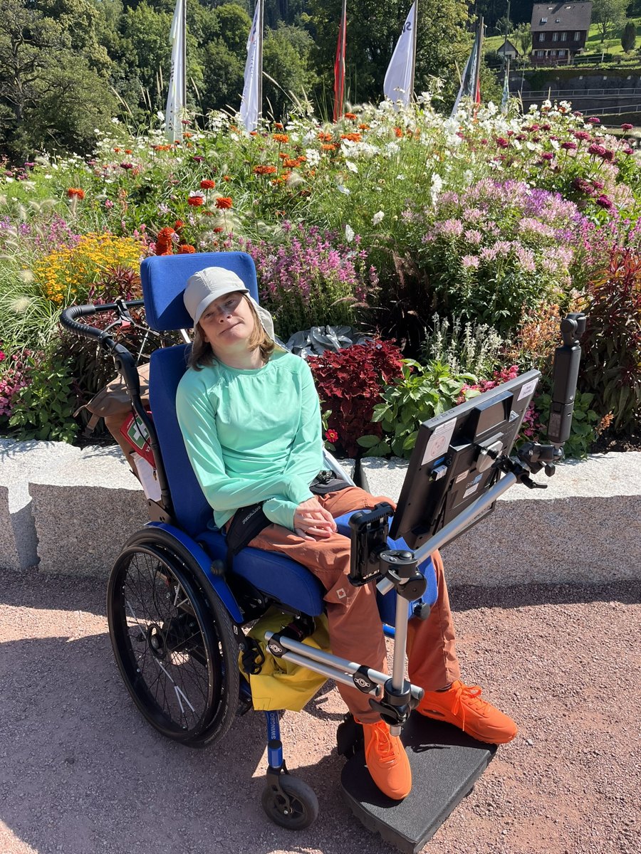 Nele Diercks auf ihrem Rollstuhlfahrrad, im Hintergrund blühende Blumen